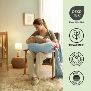Woman holding a baby in a room with Oeko-Tex and BPA-Free certification bbhugme pregnancy pillow on the right.